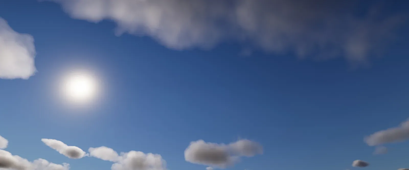 A wide panoramic view of a blue sky with scattered white volumetric clouds and a bright sun.